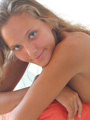 Fascinating tanned girl stripping thong and spreading her long slender legs on the couch.